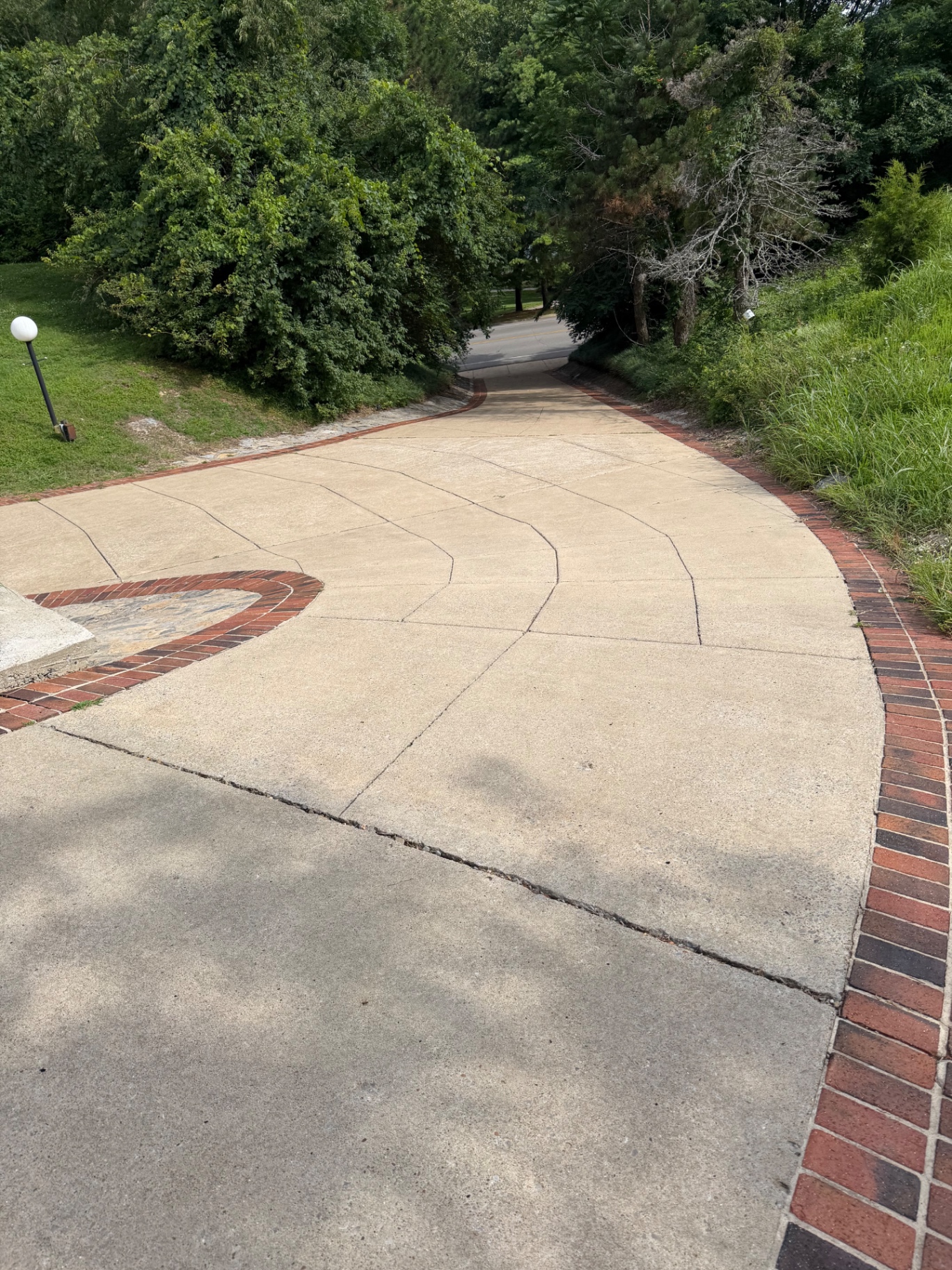 Before and after of a steep driveway section cleaning project